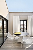 Designer table and metal chairs on roof terrace