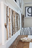 3D artwork made from birch branches above rustic wooden table