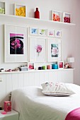 Framed floral pictures and decorated shelves in feminine bedroom