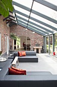 Designer lounge in conservatory extension with view into dining area of restored country house