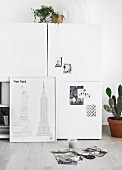 Sketches of New York leaning against white cabinet
