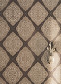 Ornamental non-woven wallpaper with a lace pattern in shades of beige