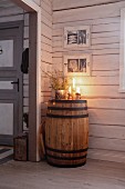 Arrangement of candles on top of old wooden barrel in wooden cabin