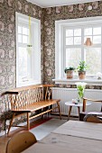 Windows, floral wallpaper and retro wooden bench in corner