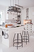 weiße Landhausküche mit Kücheninsel und Barhockern