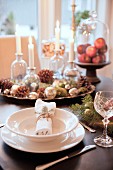Festive place setting and Christmas decorations on table