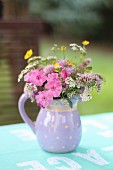 Wild flowers in ceramic jug on garden table