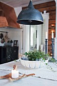 Black ceiling lamp above dining table in rustic kitchen-dining room