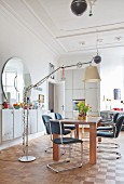 Wooden table, cantilever chairs and standard lamp in kitchen-dining room of period apartment