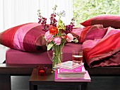 Bedroom with flowers on bedside table and red accents