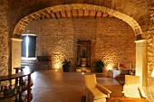 Mediterranes Wohnzimmer mit Natursteinwand und Bogen