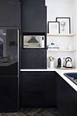 Schwarze Einbauküche mit weißer Küchenarbeitsplatte