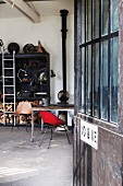 View into workshop interior with vintage stove and black shelving
