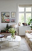 Vase of wildflowers on marble coffee table and house plants on flower stand