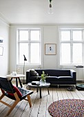 Wohnzimmer im skandinavischen Stil mit schwarzem Sofa