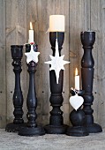 Christmas-tree baubles dipped in plaster and hung from black candlesticks