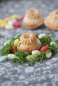 Miniature bundt cakes in nests of cress and colourful sugar eggs