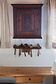 Old wall-mounted cabinet above wooden spoons in rack