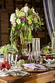 Festlich gedeckter Tisch mit Blumen und Kerzen in ländlichem Stil