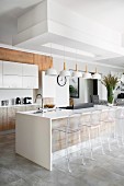Transparent bar stools at island counter in modern kitchen