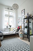 Black and white rug, display cabinet and action figures in boy's bedroom in period apartment