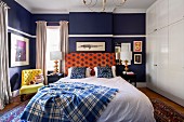 Double bed in the bedroom with dark blue wall and white built-in closet