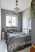 White board floor, chandelier and dreamcatcher in bedroom in shades of grey