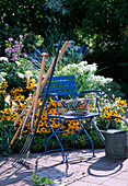 Garden tool leaning against blue chair