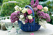 Basket with syringa vulgaris (lilac), viburnum