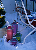 Colorful lanterns in the snow on the balcony