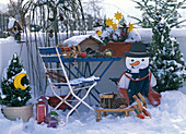Balcony in winter with birdhouse, wooden snowman