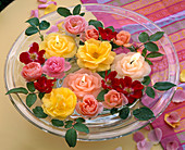 Rose blossoms, flower candles floating in glass bowl