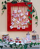 Advent calendar made of white parcels in red picture frame