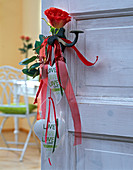 Pink (rose) with red ribbon tied to doorknob