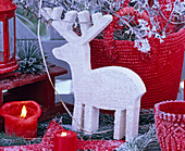 White wooden moose with hoarfrost, red candles, red bag