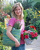 Young woman coming from shopping, basket with gerbera in tissue paper