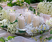 Hydrangea (hydrangea) on tray with white candles in glasses