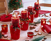Christmas table decoration with red candles in glass pots