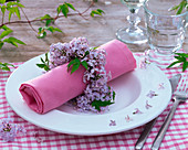 Napkin ring made of Syringa (lilac) around pink napkin
