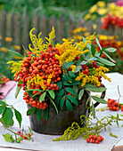 Arrangement of Sorbus (Rowanberry) and Solidago (Goldenrod) in pitcher