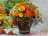 Late summer bouquet in homemade basket with wooden floor