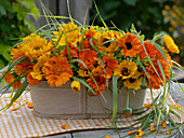 Jardiniere with calendula (marigold) and grasses