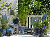 Blue balcony with grasses, old wine boxes as furniture
