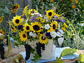 Late summer bouquet with sunflowers, bluebells and grapes