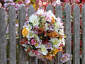 Autumnal flower wreath at the fence