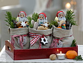Handstitched linen Santa Claus bag on red wooden tray