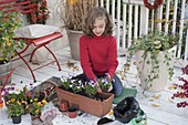 Girl planting box with horned violets and tulip bulbs