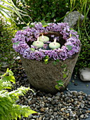 Wreath from syringa (lilac) on stone trough with floating candles