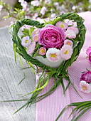 Bouquet of rose and daisies in a grass heart