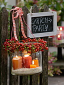 Lanterns with wreath made of roses (rosehip) tied to fence